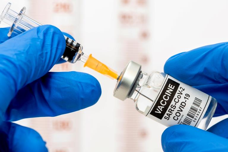 Vaccinationsnål stukket i medicinglas